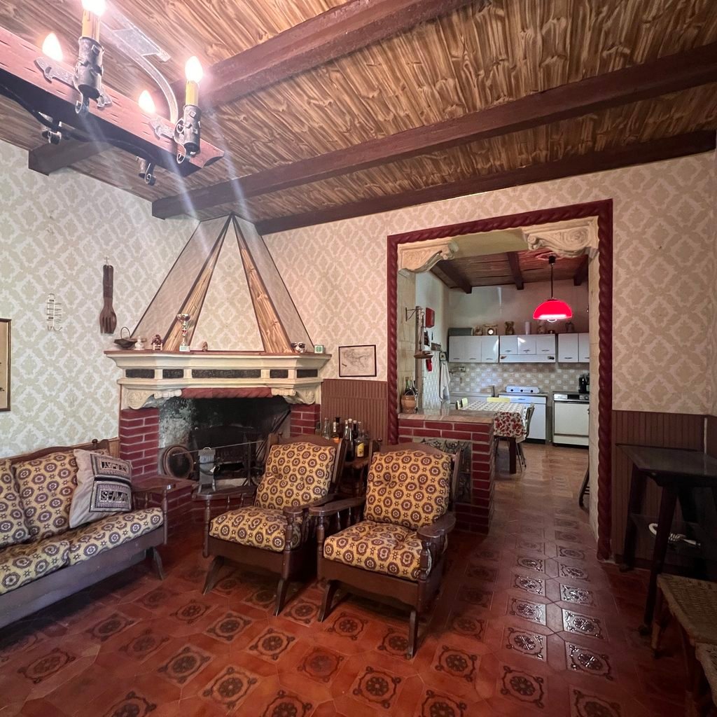 Soggiorno con camino e arredi datati prima della valorizzazione immobiliare